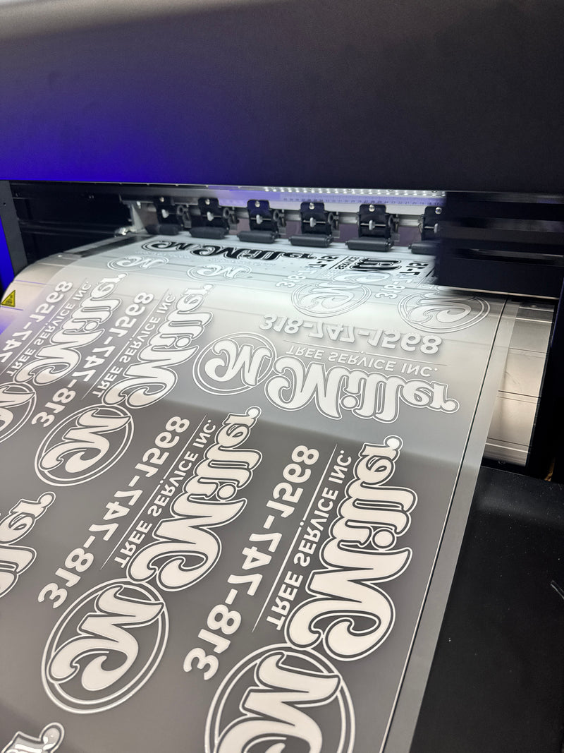 A sheet of logos printed on film coming off a DTF printer
