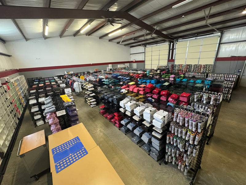 Racks of folded blank t-shirts and hoodies inside the Creative Design & Supply warehouse in Bossier City